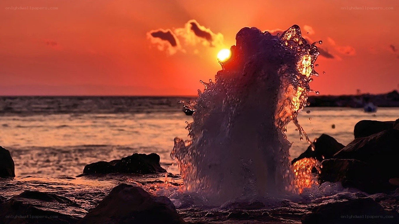Sunset wave splashing on rocks