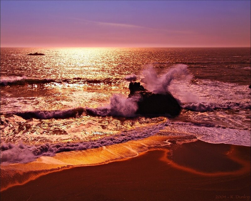 Sunset waves crash on rocks