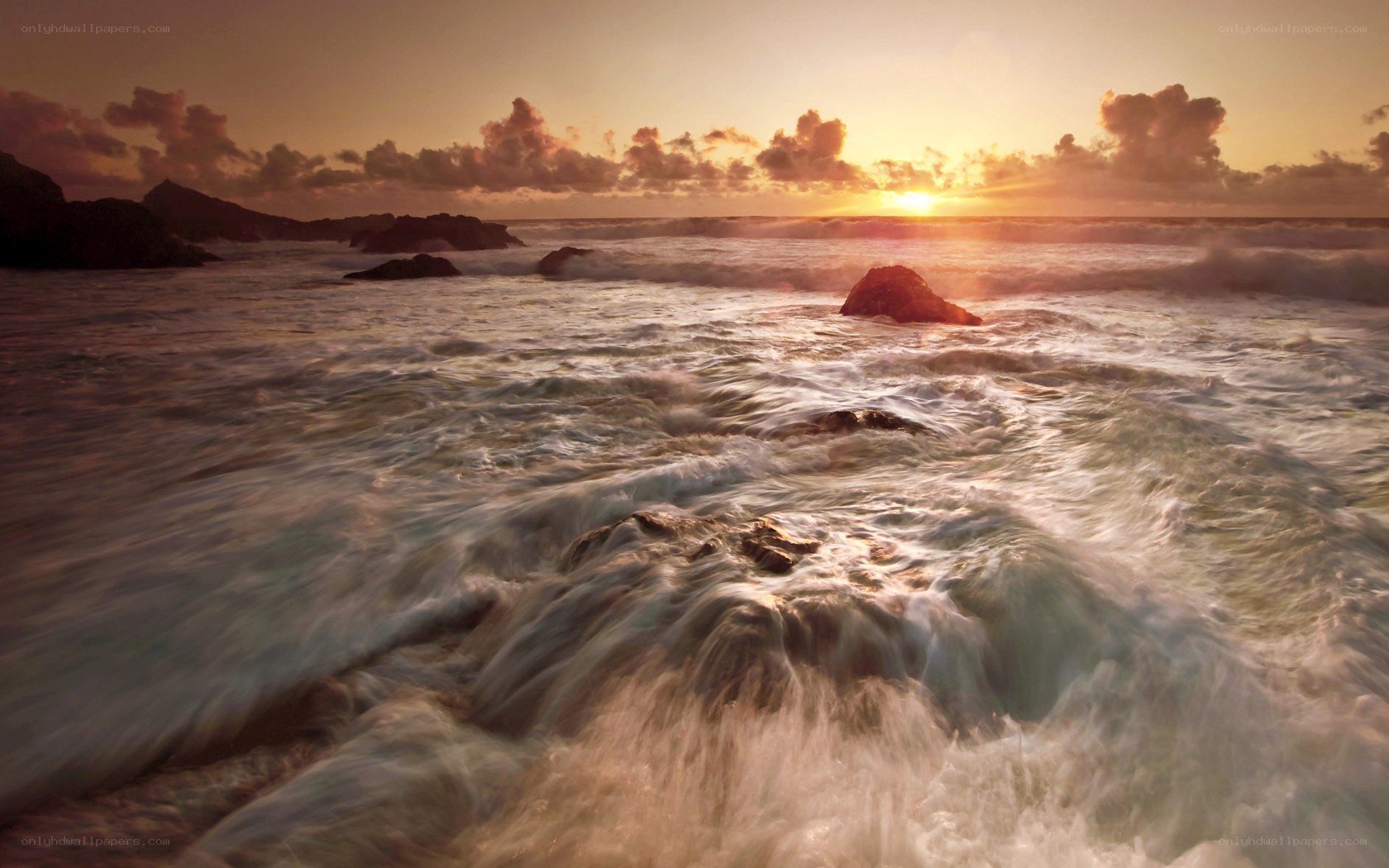 Sunset waves crashing on rocks