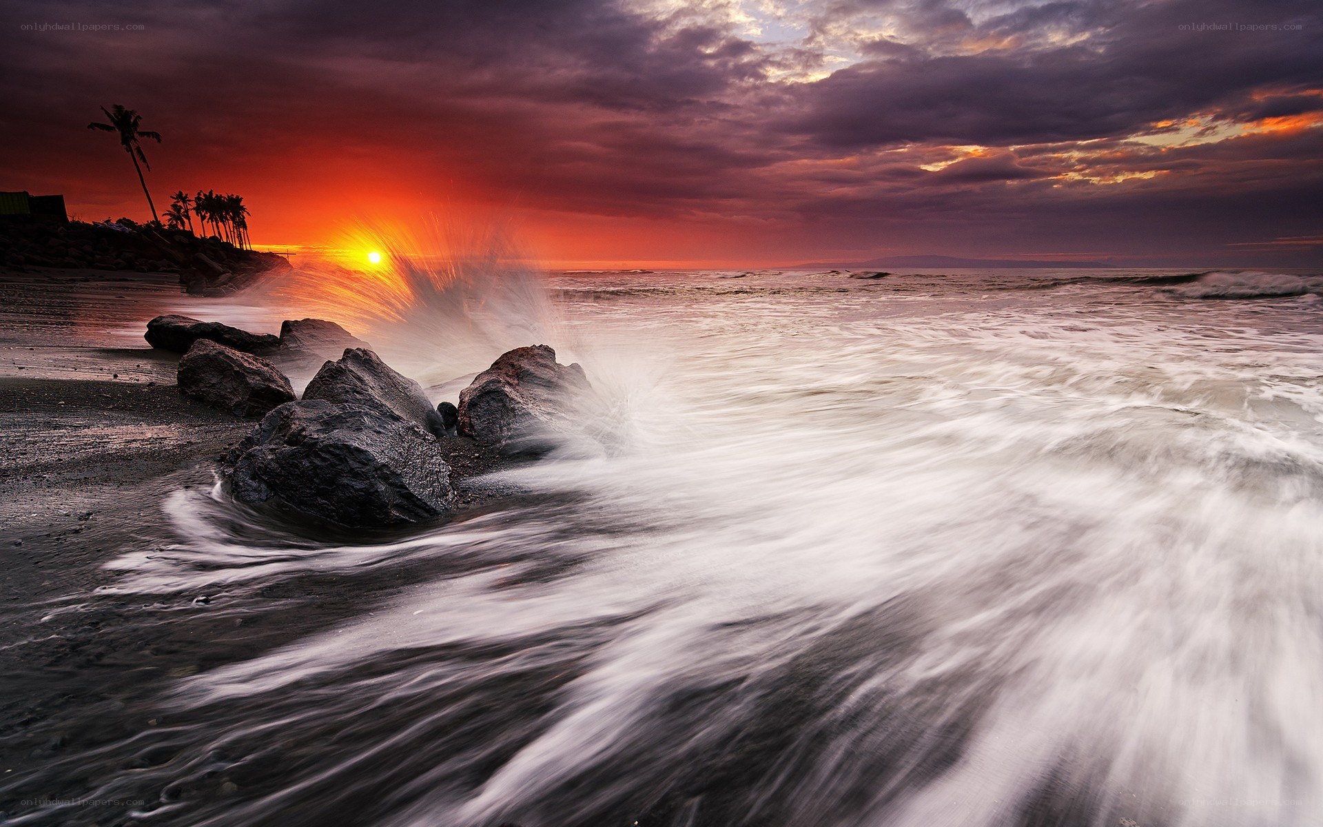 Sunset waves crashing on rocks