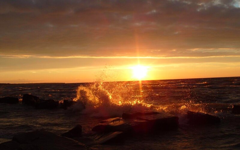 Sunset waves crashing on rocks