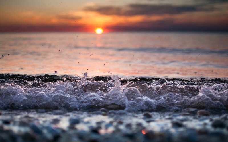 Sunset waves on pebble beach
