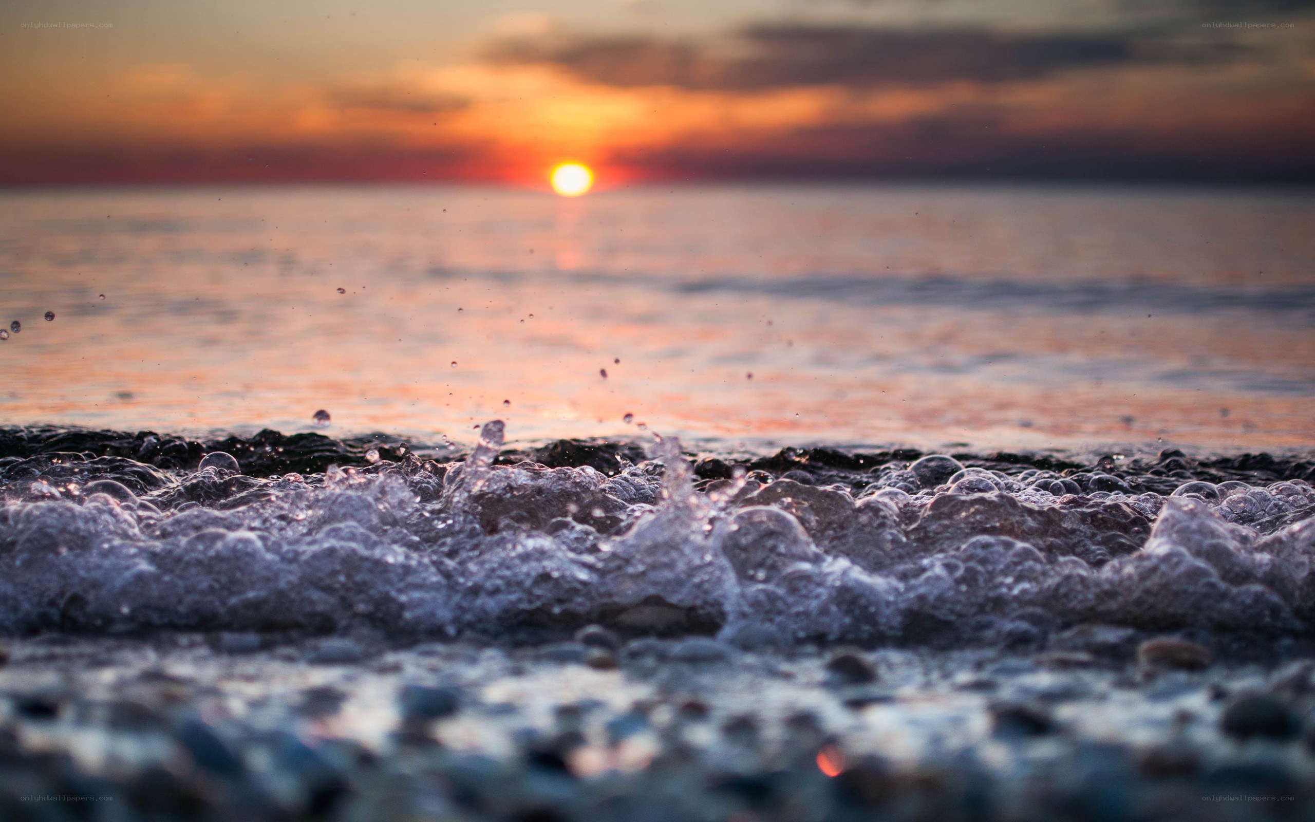 Sunset waves on pebble beach