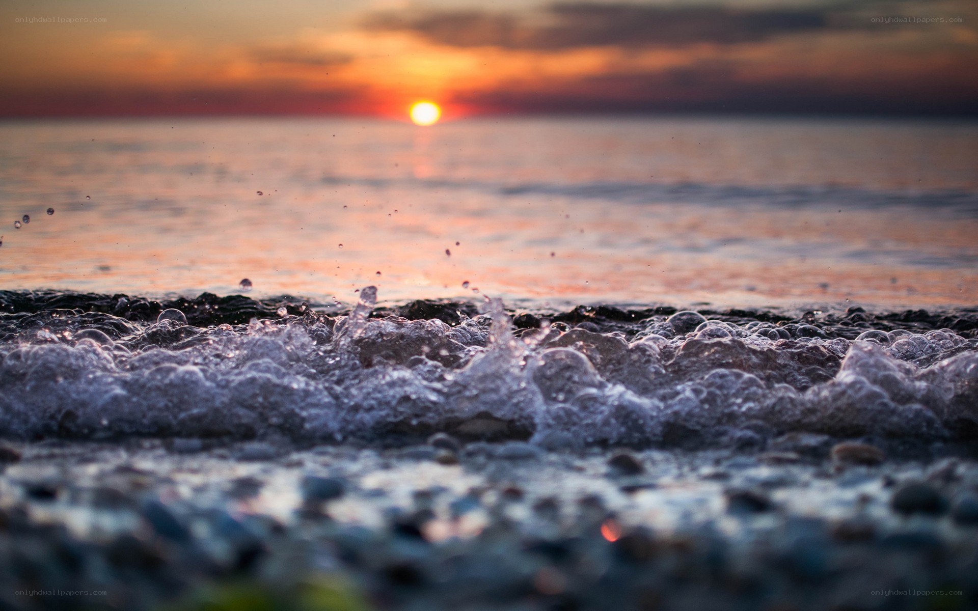 Sunset waves on pebble beach