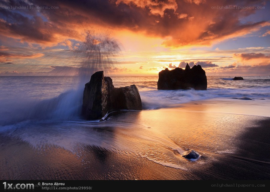 Sunset waves on rocky beach