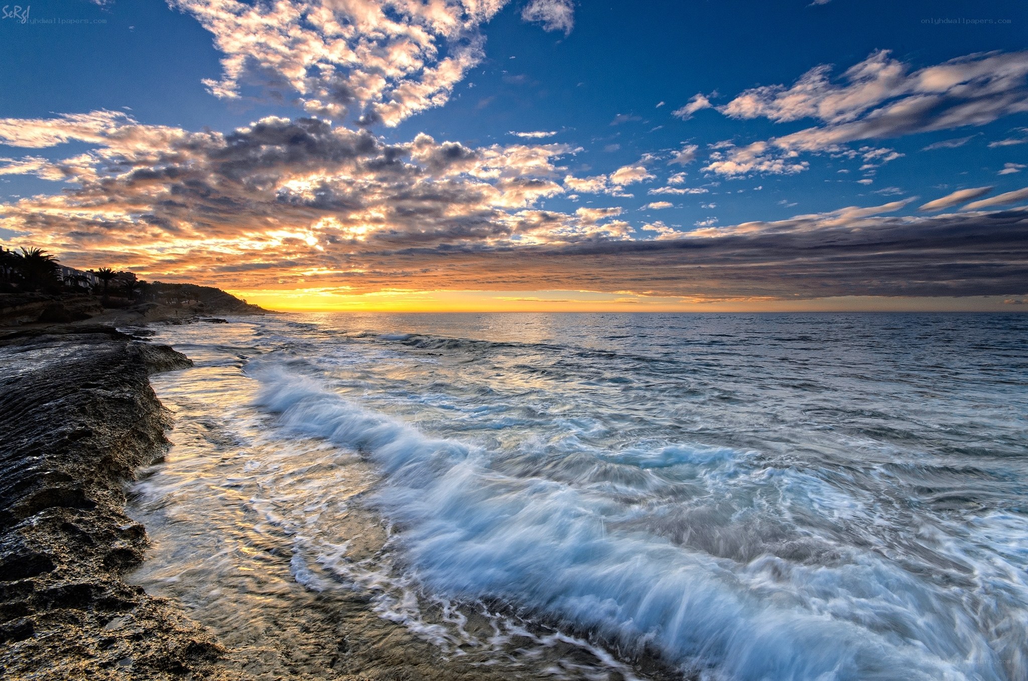 Sunset waves on rocky shore