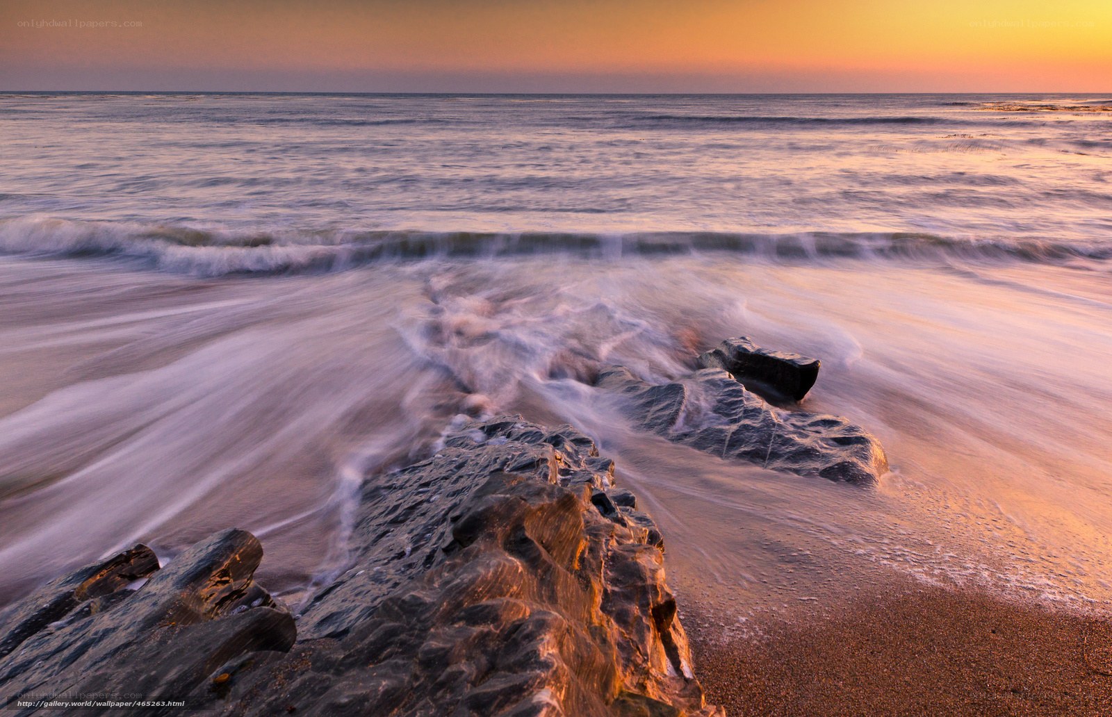 Sunset waves on rocky shore