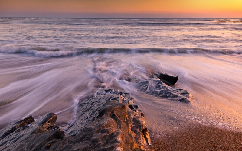 Sunset waves on rocky shore