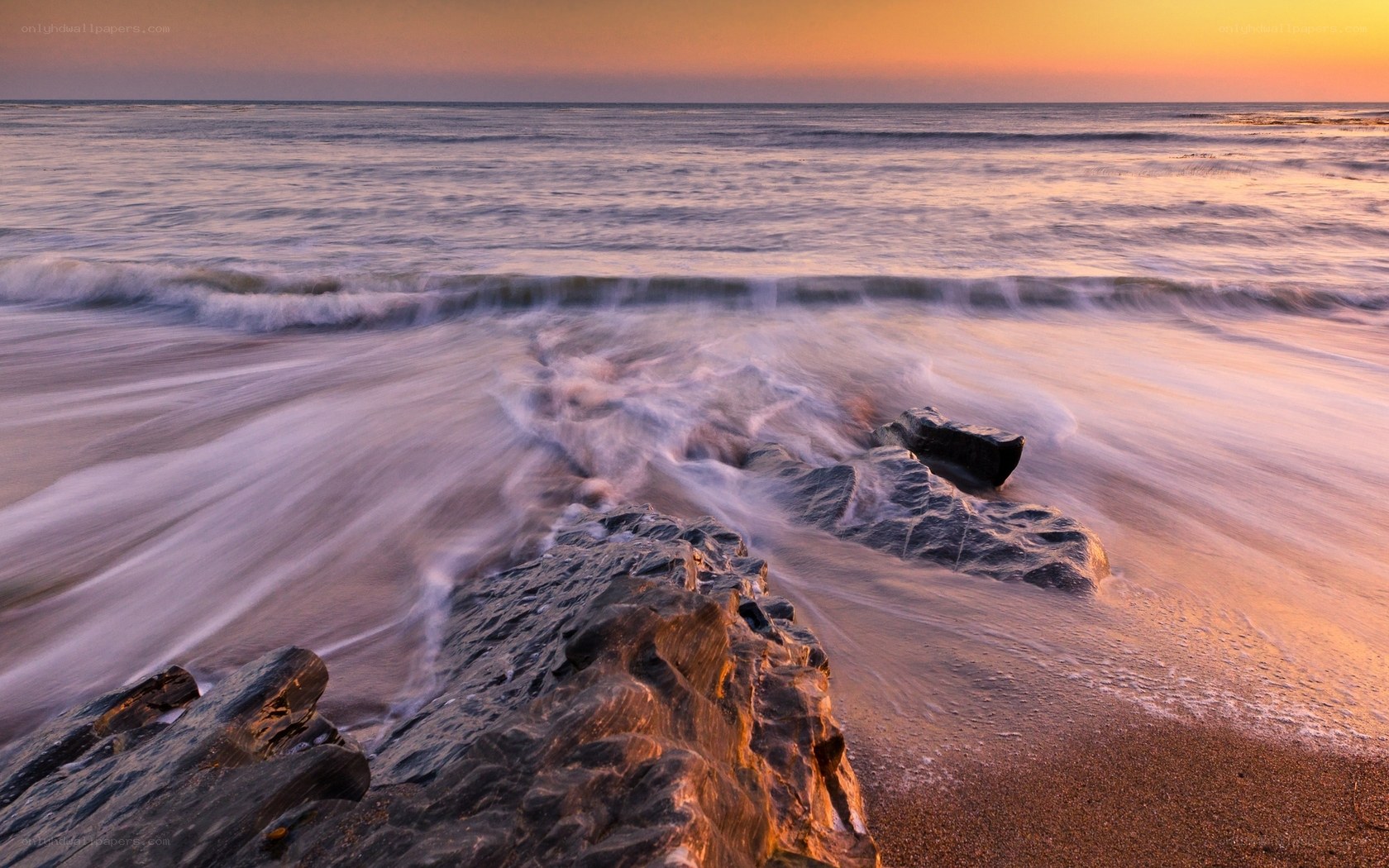 Sunset waves on rocky shore
