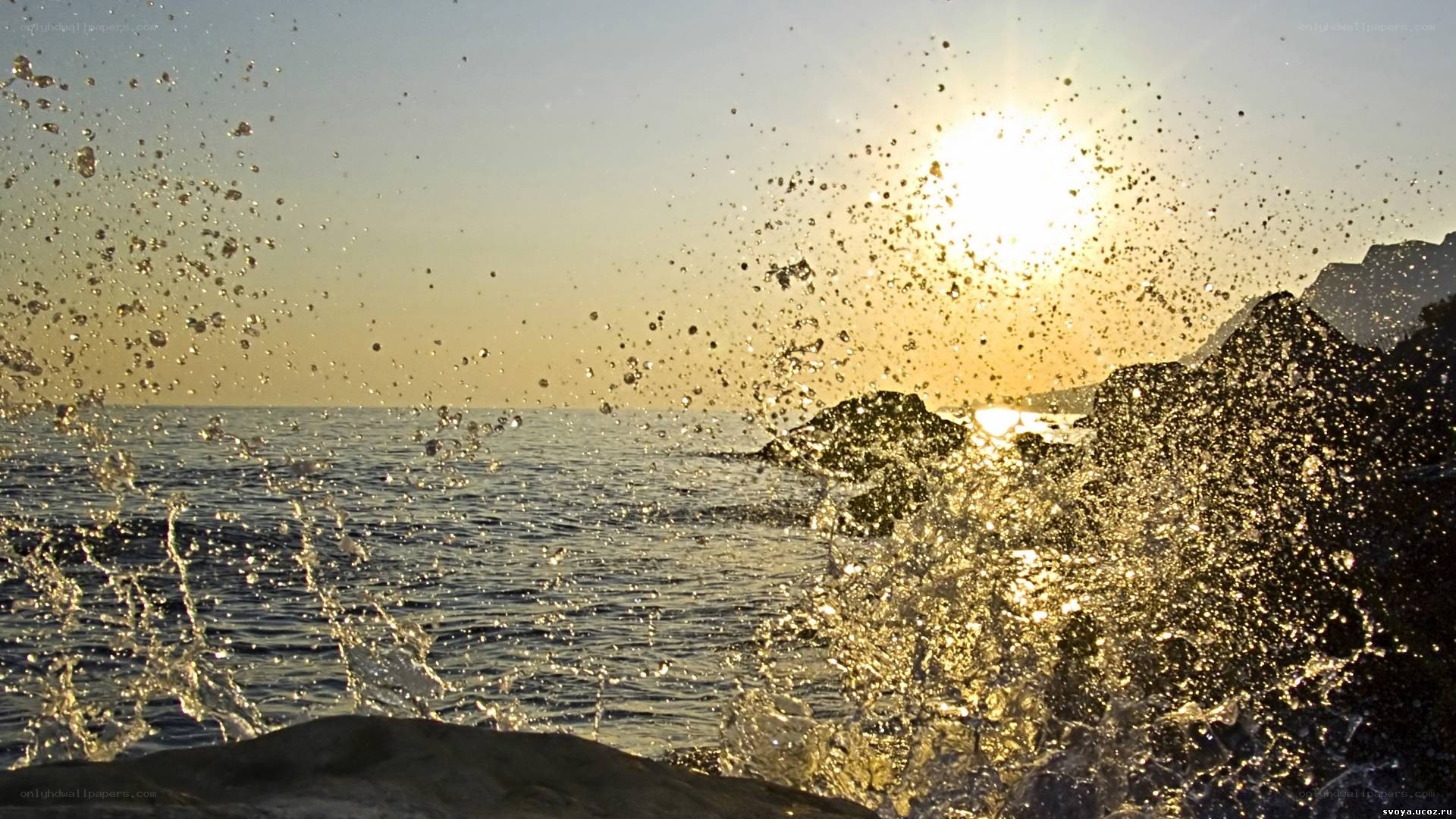 Sunset waves splashing on rocks