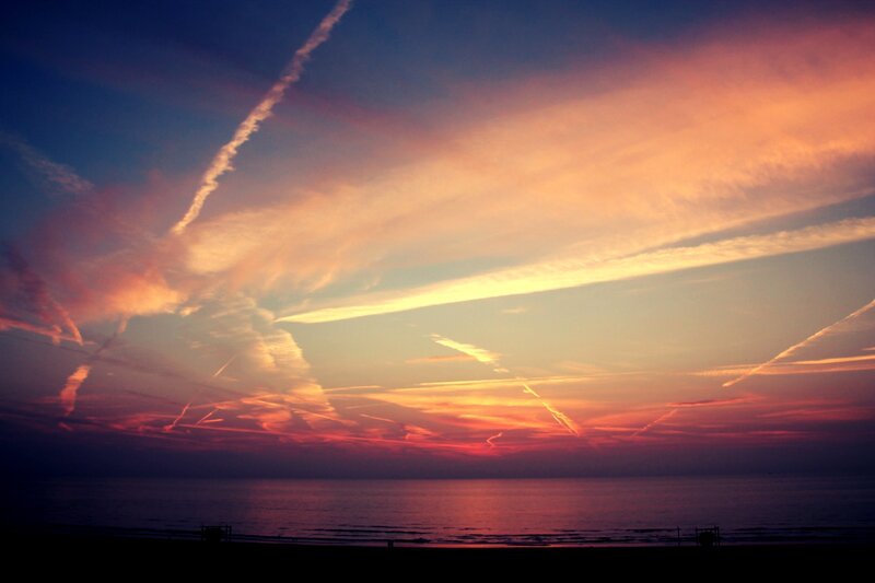 Sunset with contrails over the sea