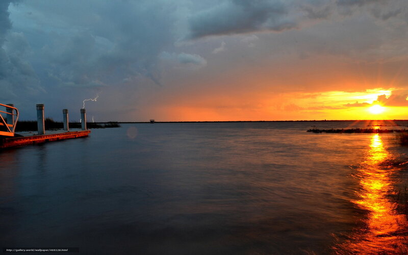 Sunset with lightning over water