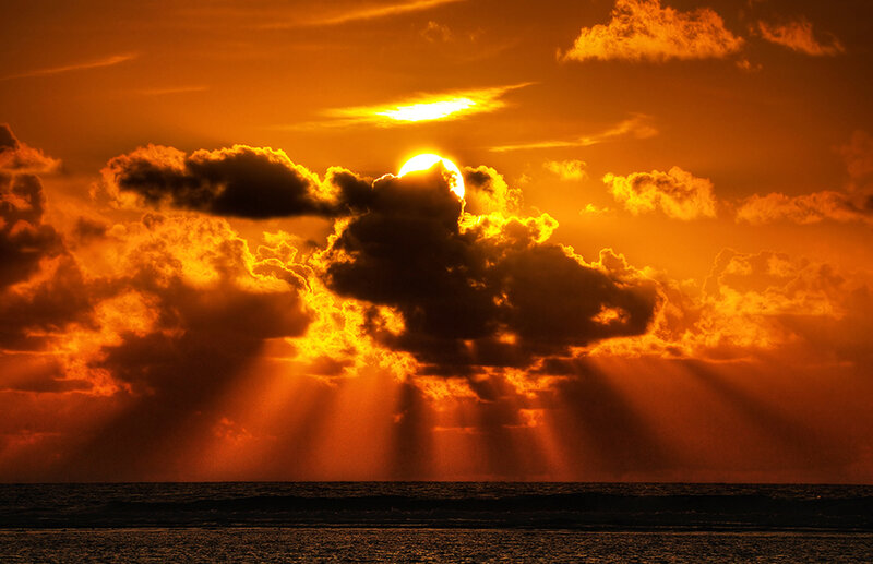 Sunset with sunbeams over ocean