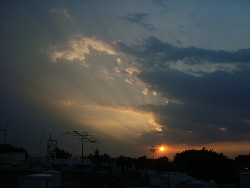Sunset with sunbeams over rooftops