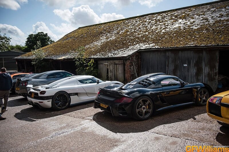supercars parked outside barn