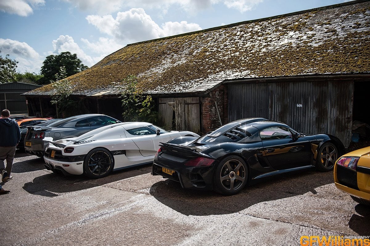 supercars parked outside barn
