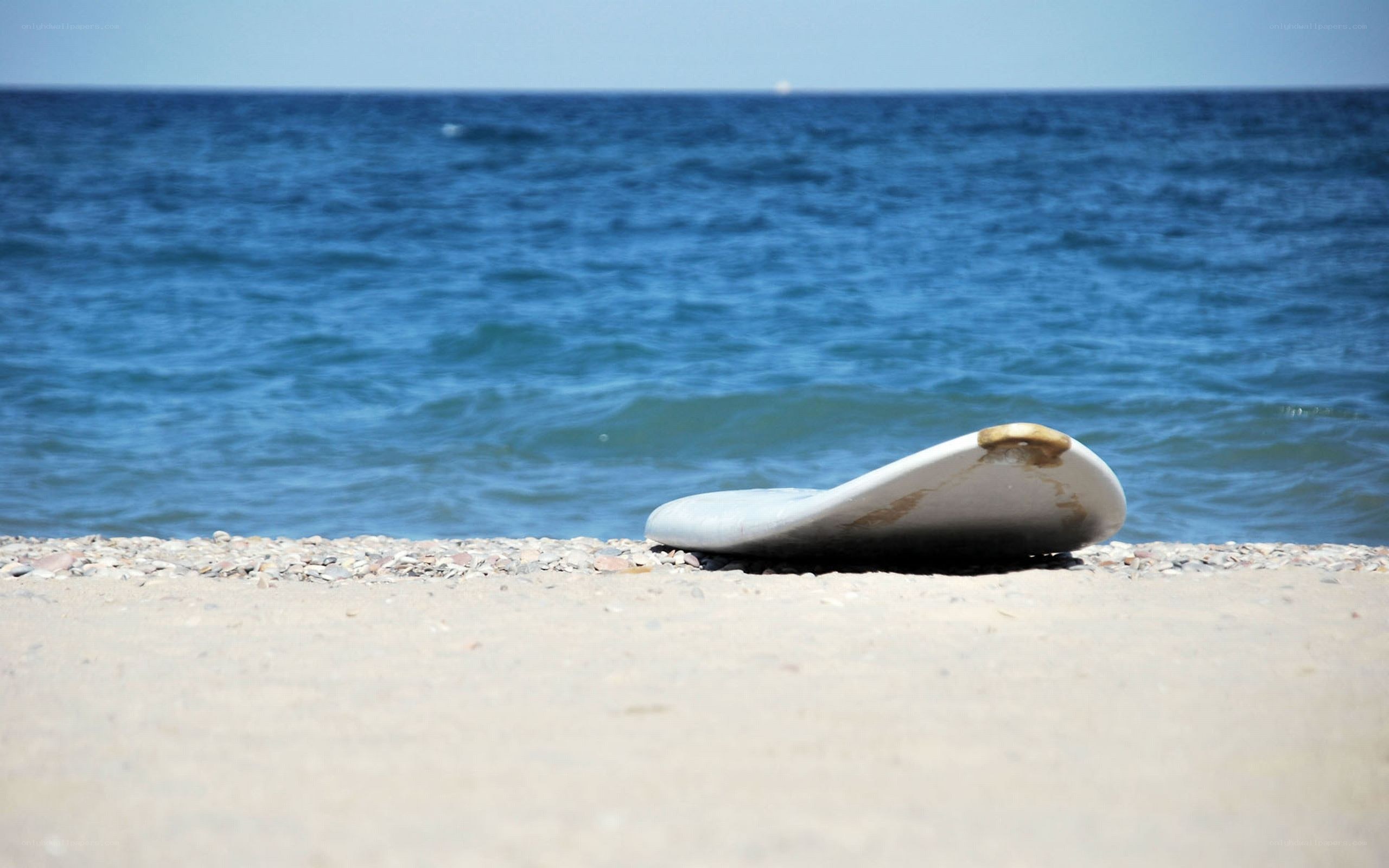 Surfboard on a pebble beach