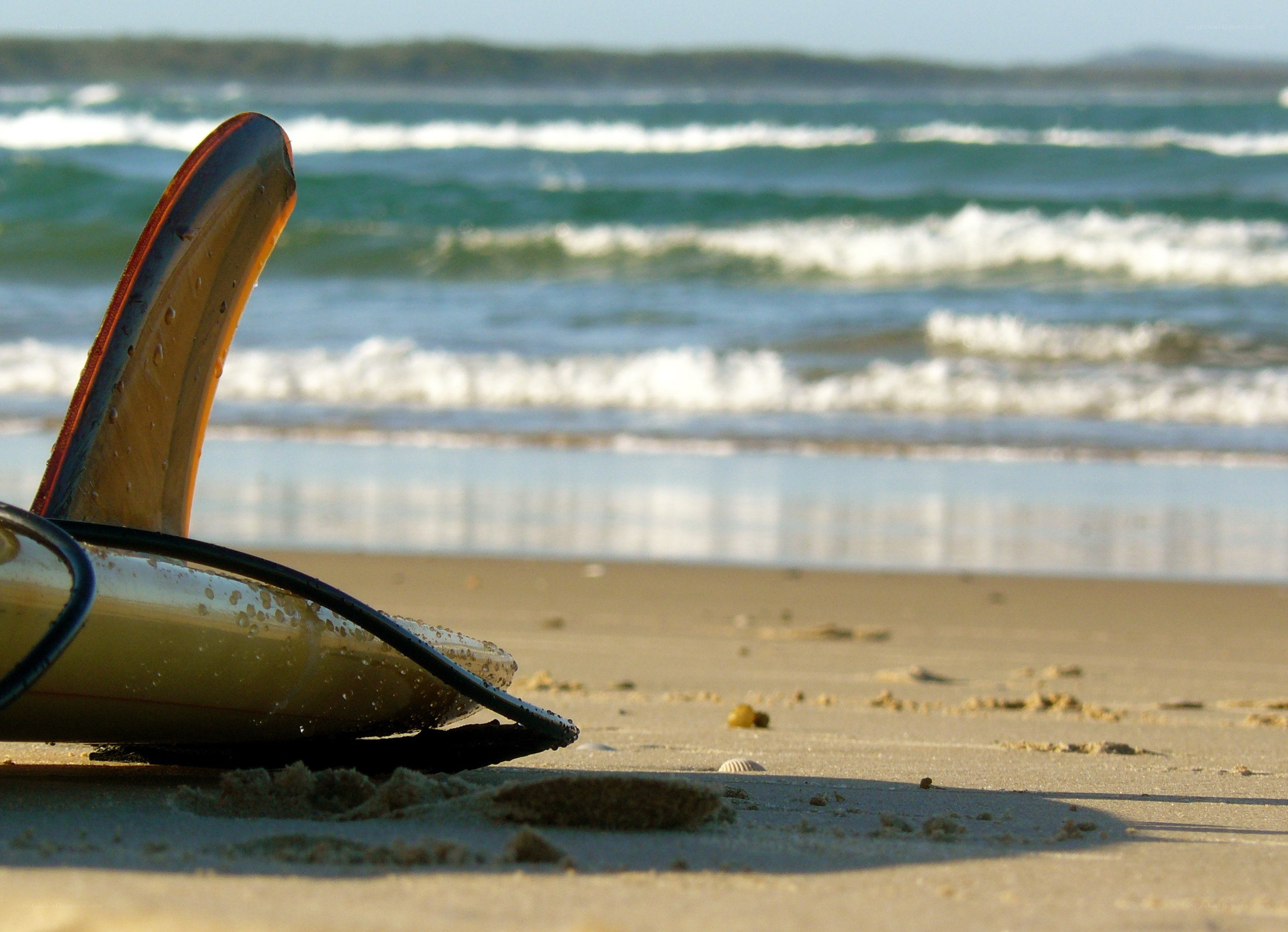 Surfboard on sandy beach