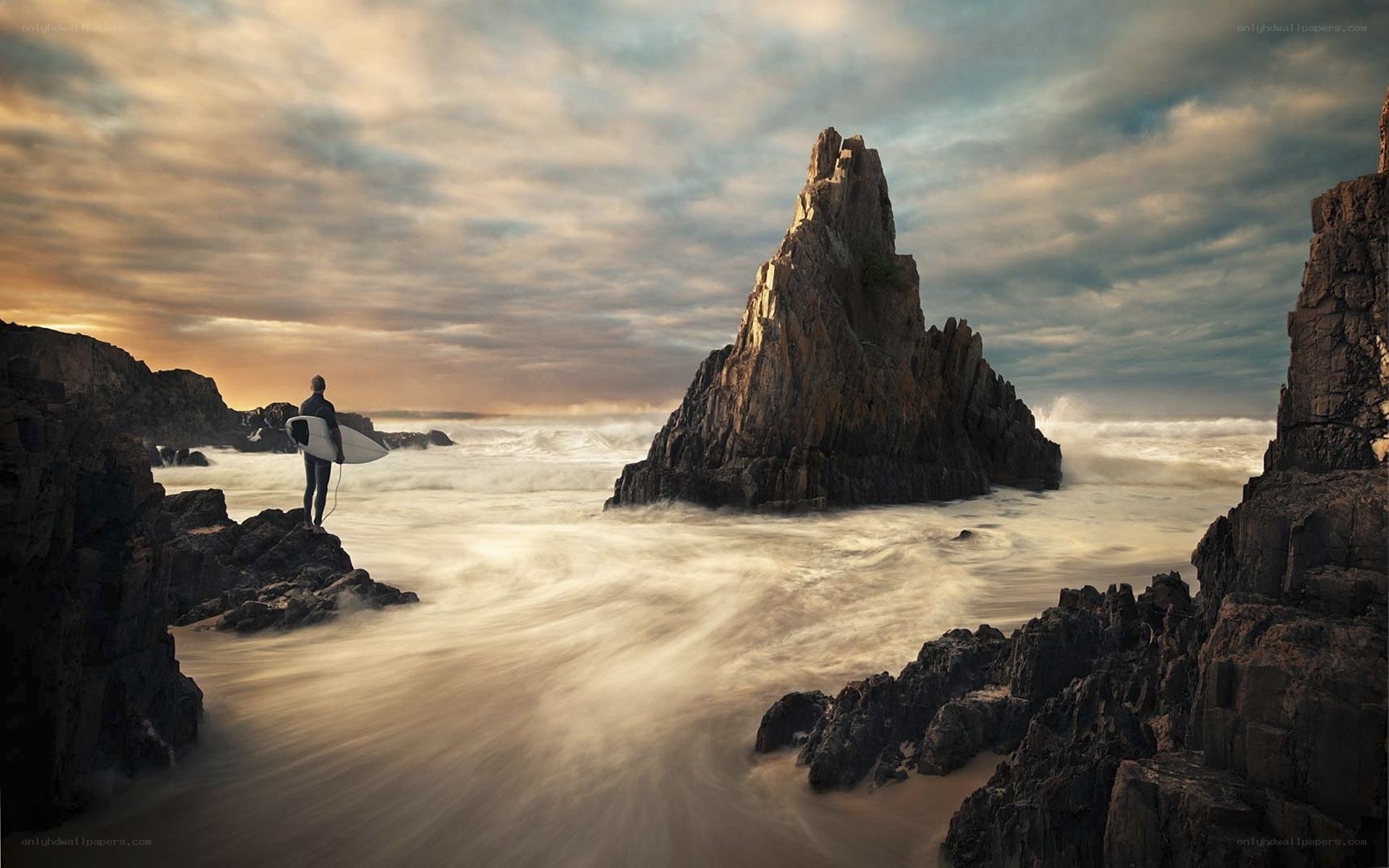 Surfer at rocky coastline