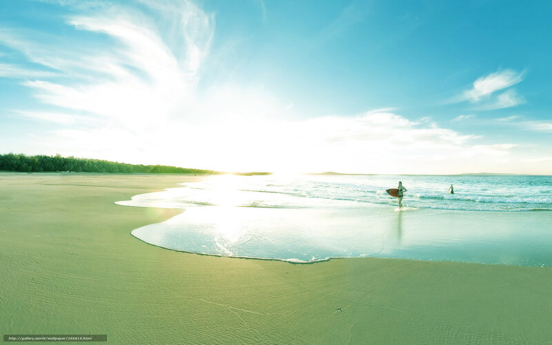 Surfer at sunrise on a sandy beach