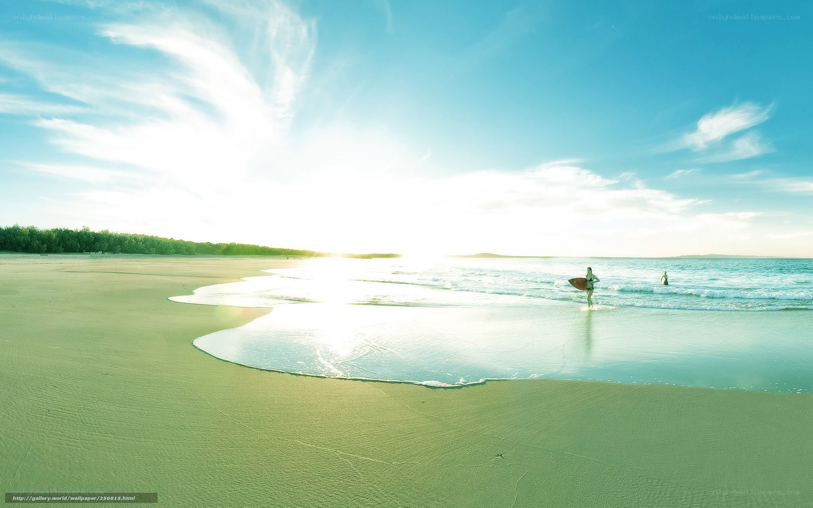Surfer at sunrise on a sandy beach