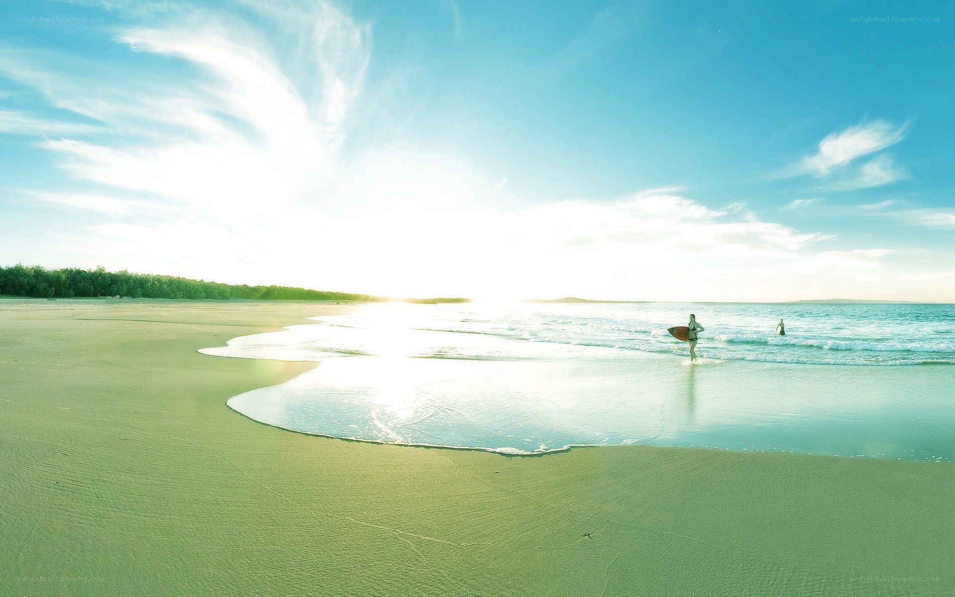 Surfer at sunset on a sandy beach