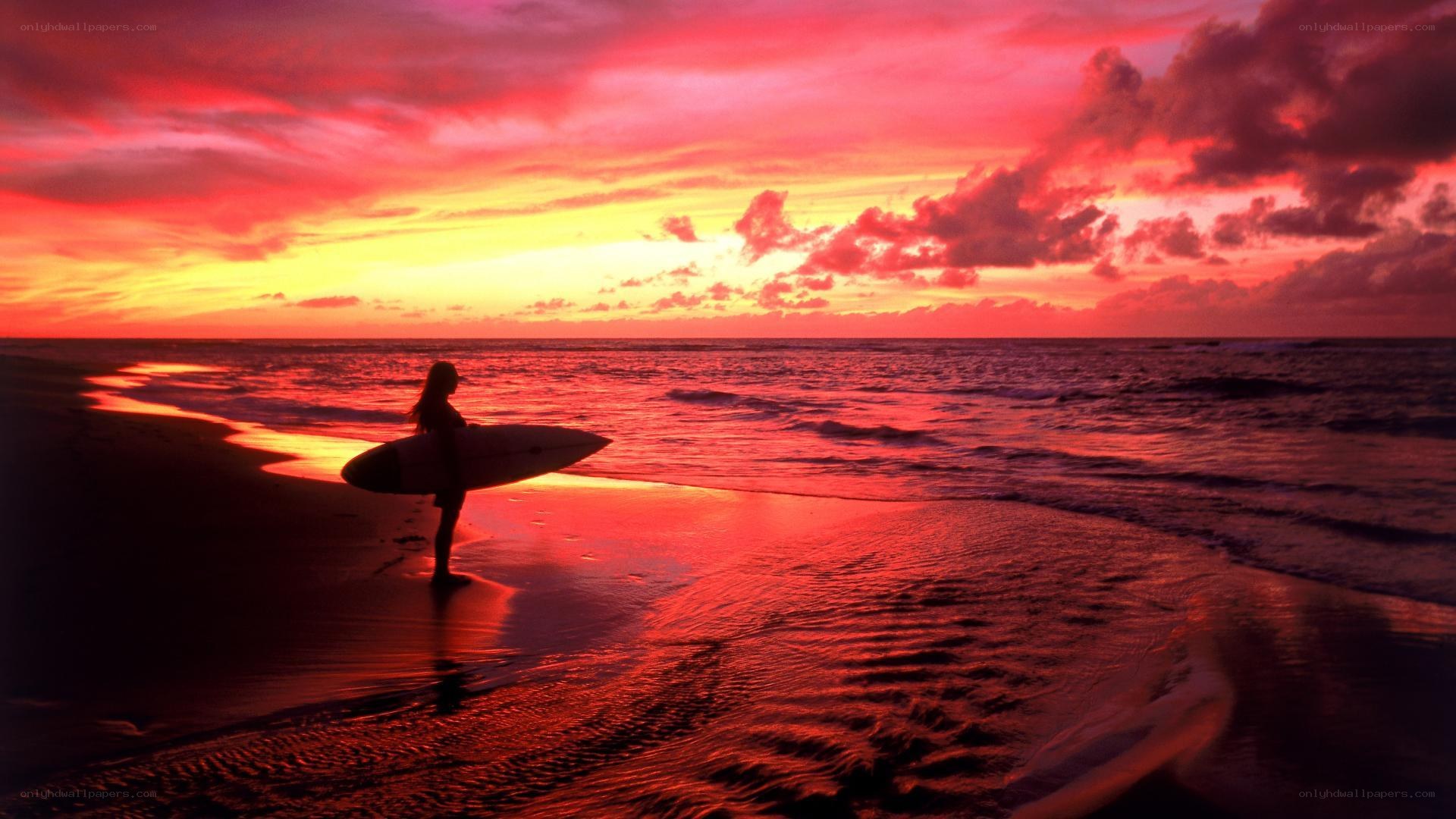 Surfer at sunset on beach
