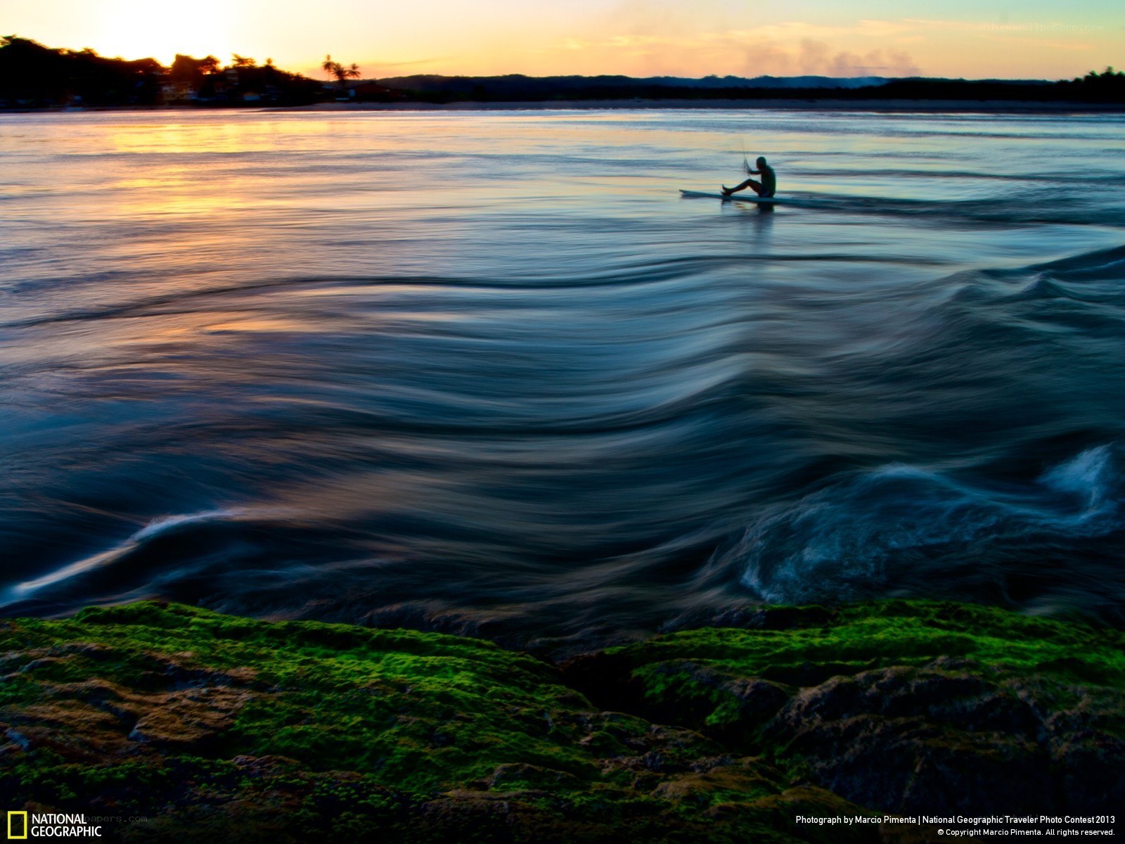 Surfer at sunset on calm water