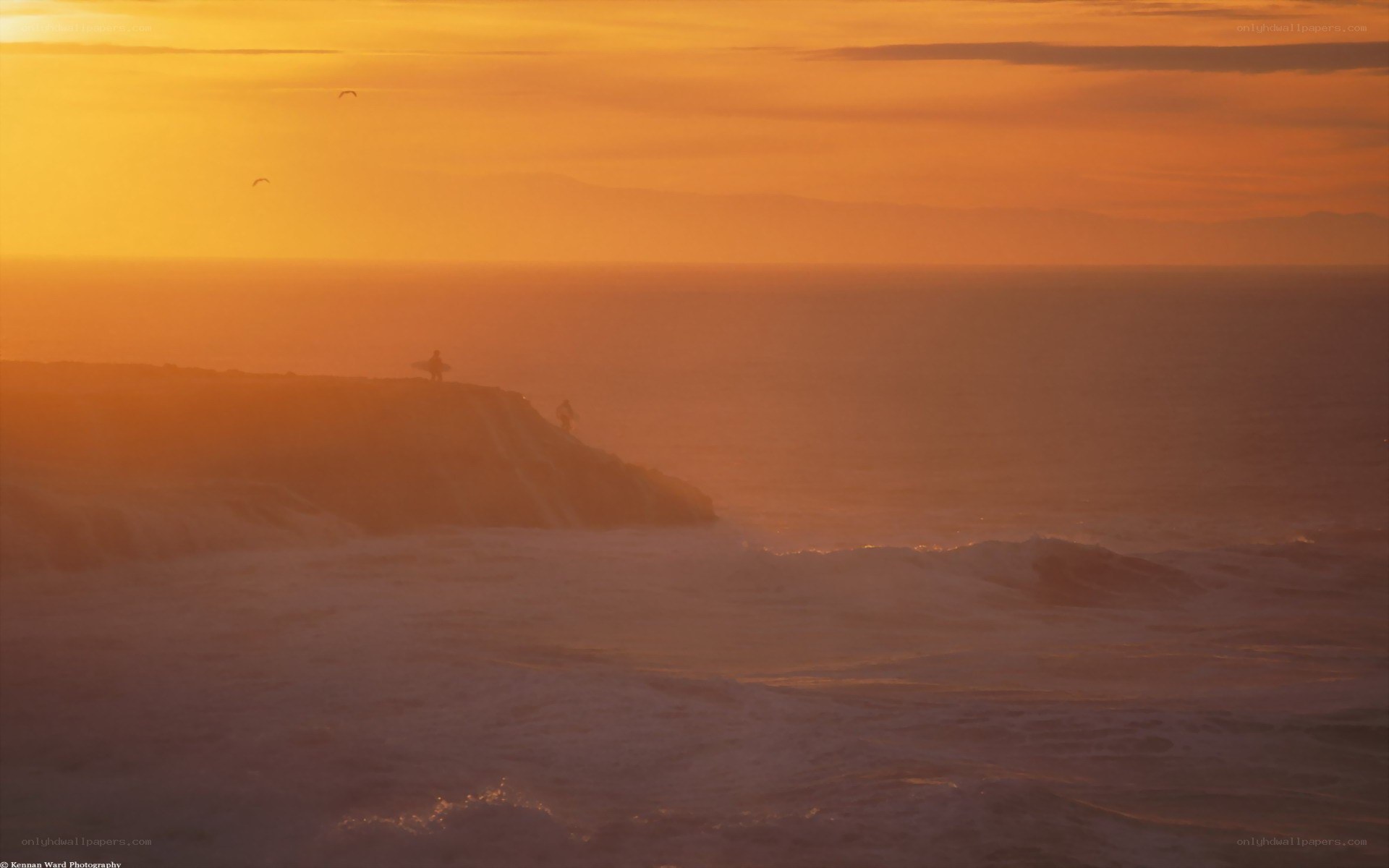 Surfer at sunset on cliff