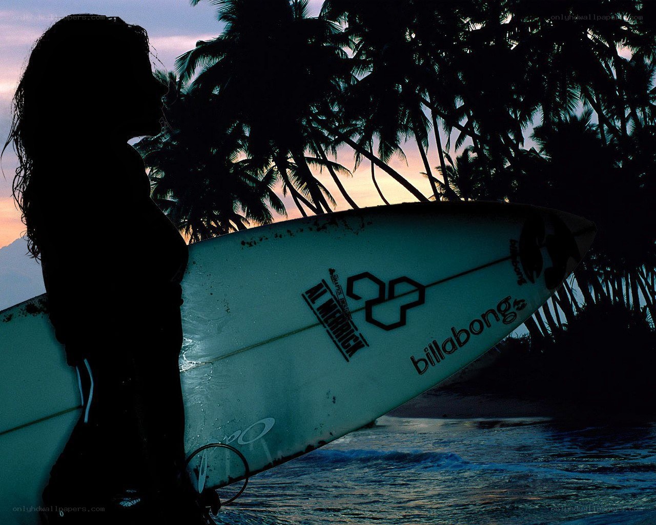 Surfer at sunset with palm trees