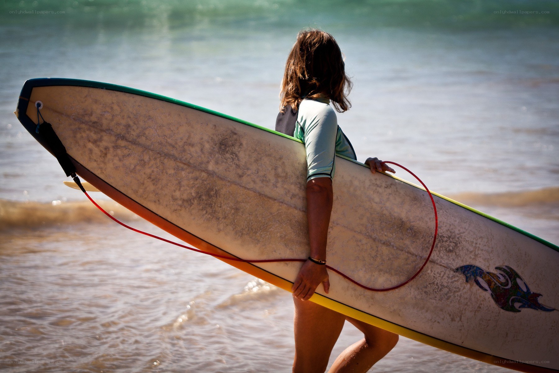 Surfer carrying board at beach