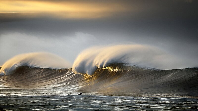Surfer facing massive waves