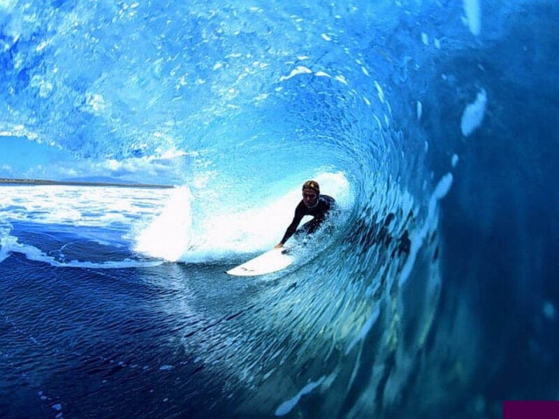 Surfer in a blue wave tunnel