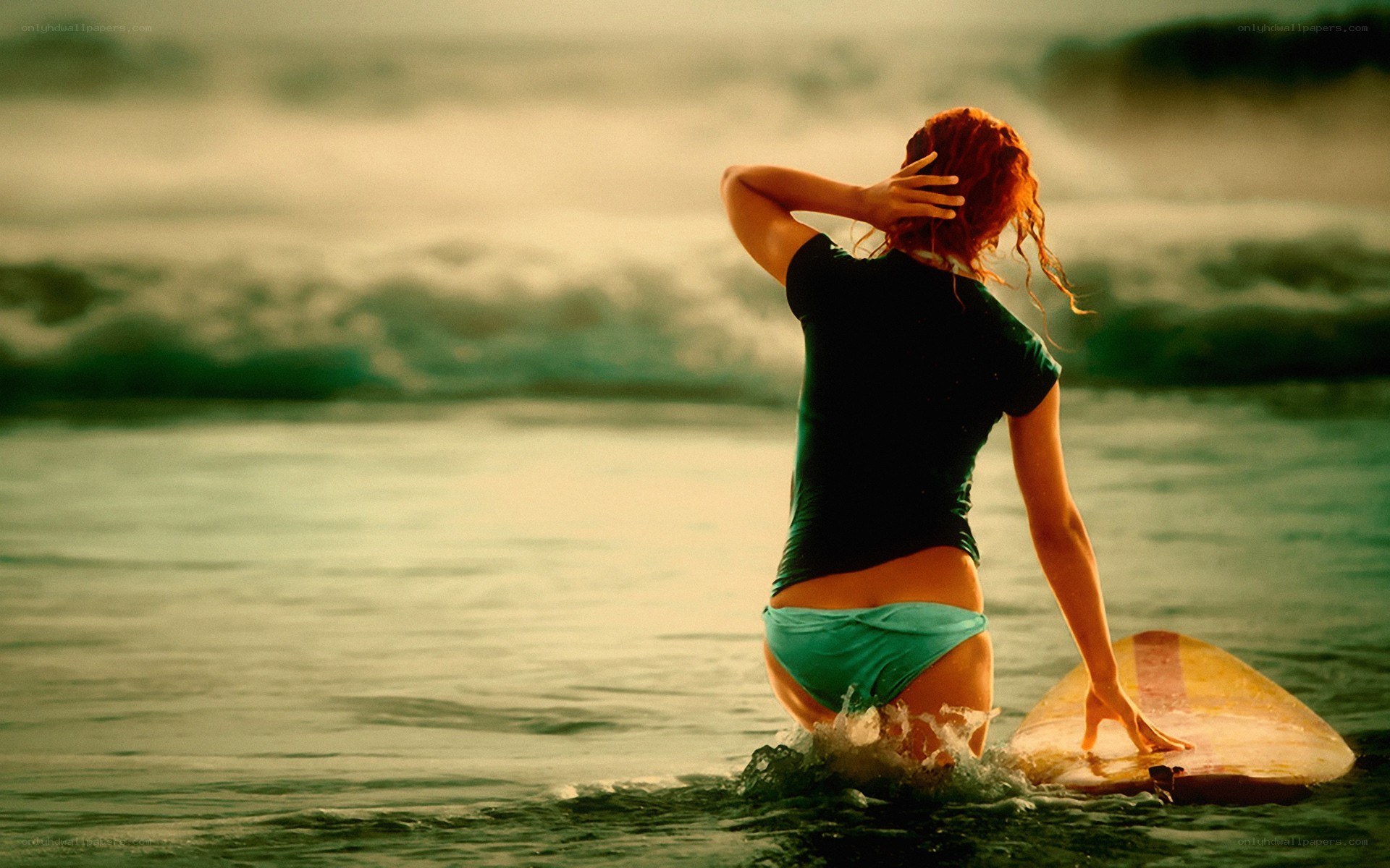 Surfer in ocean at sunset