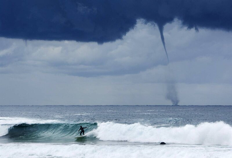 Surfer near waterspout