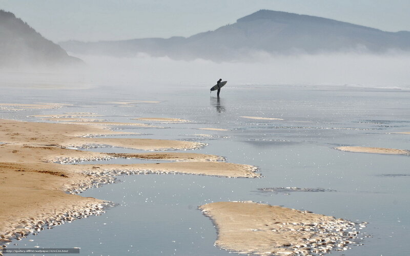 Surfer on a misty beach