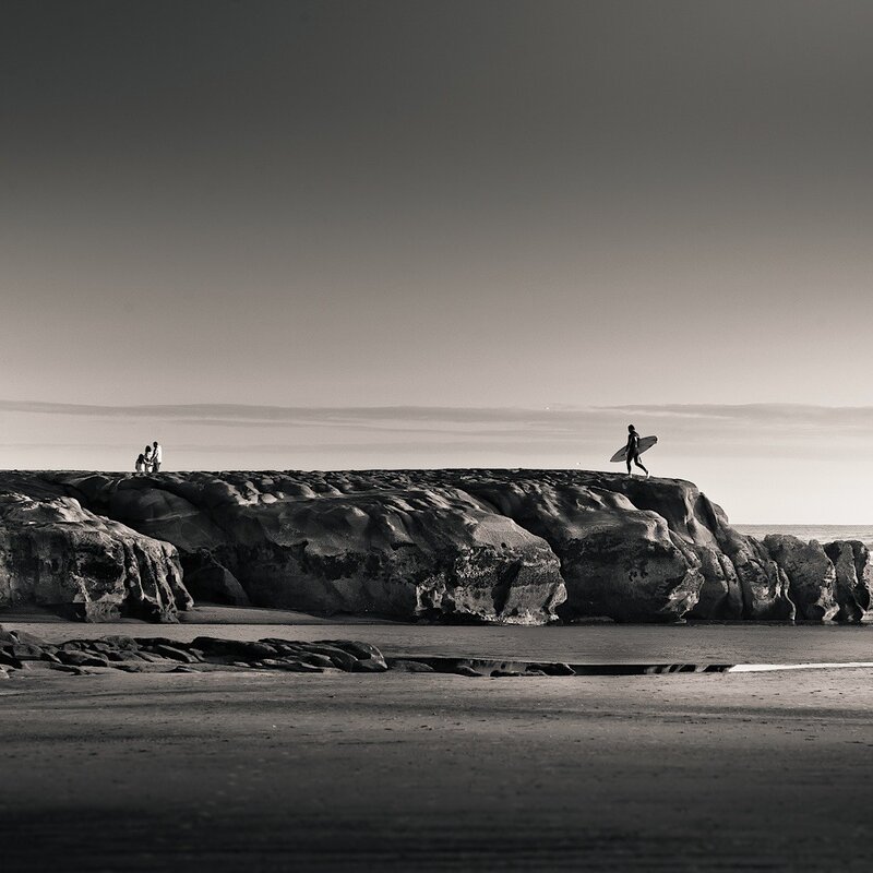 Surfer on a rocky shore