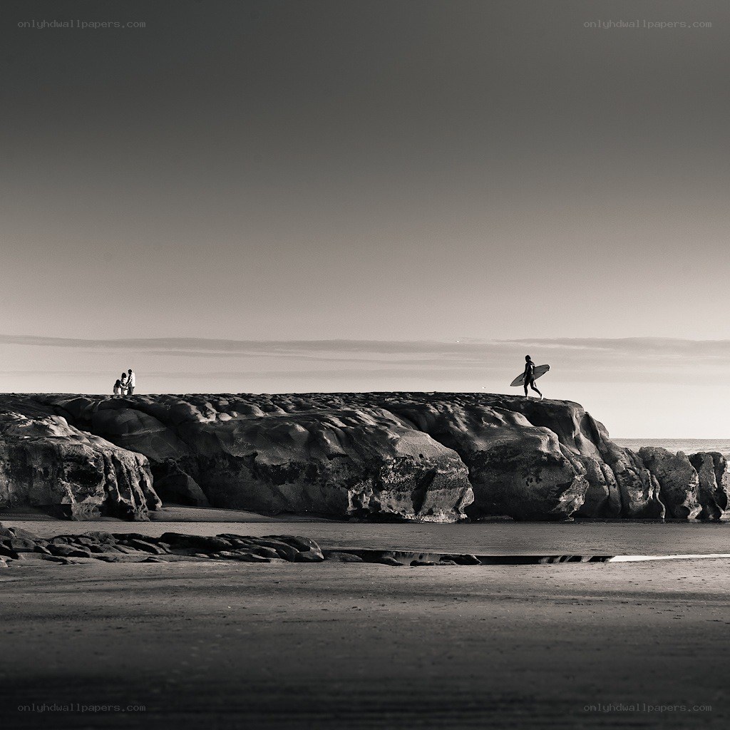 Surfer on a rocky shore