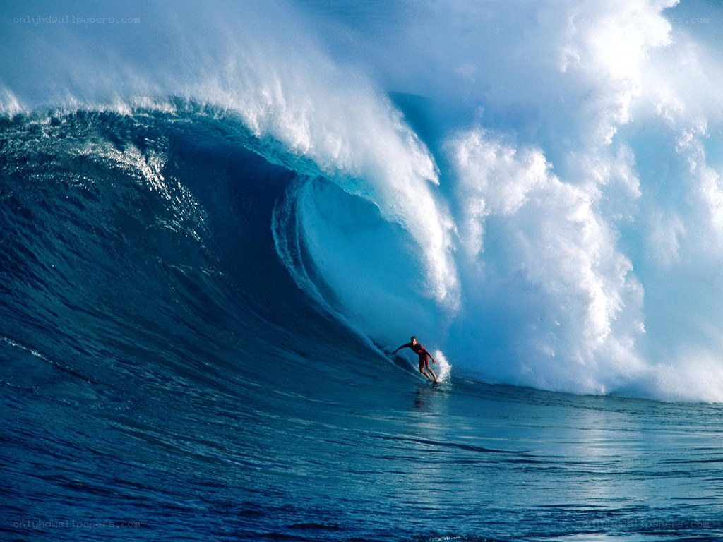 Surfer riding large ocean wave