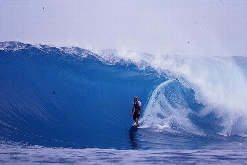 Surfer riding large ocean wave