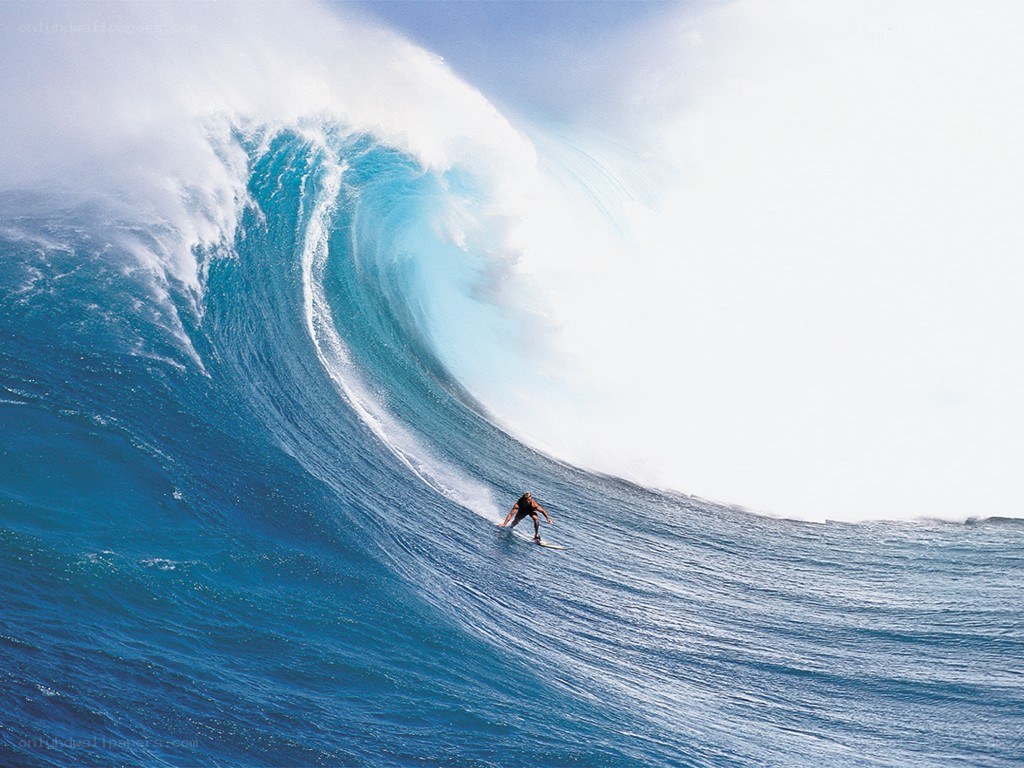 Surfer riding large ocean wave