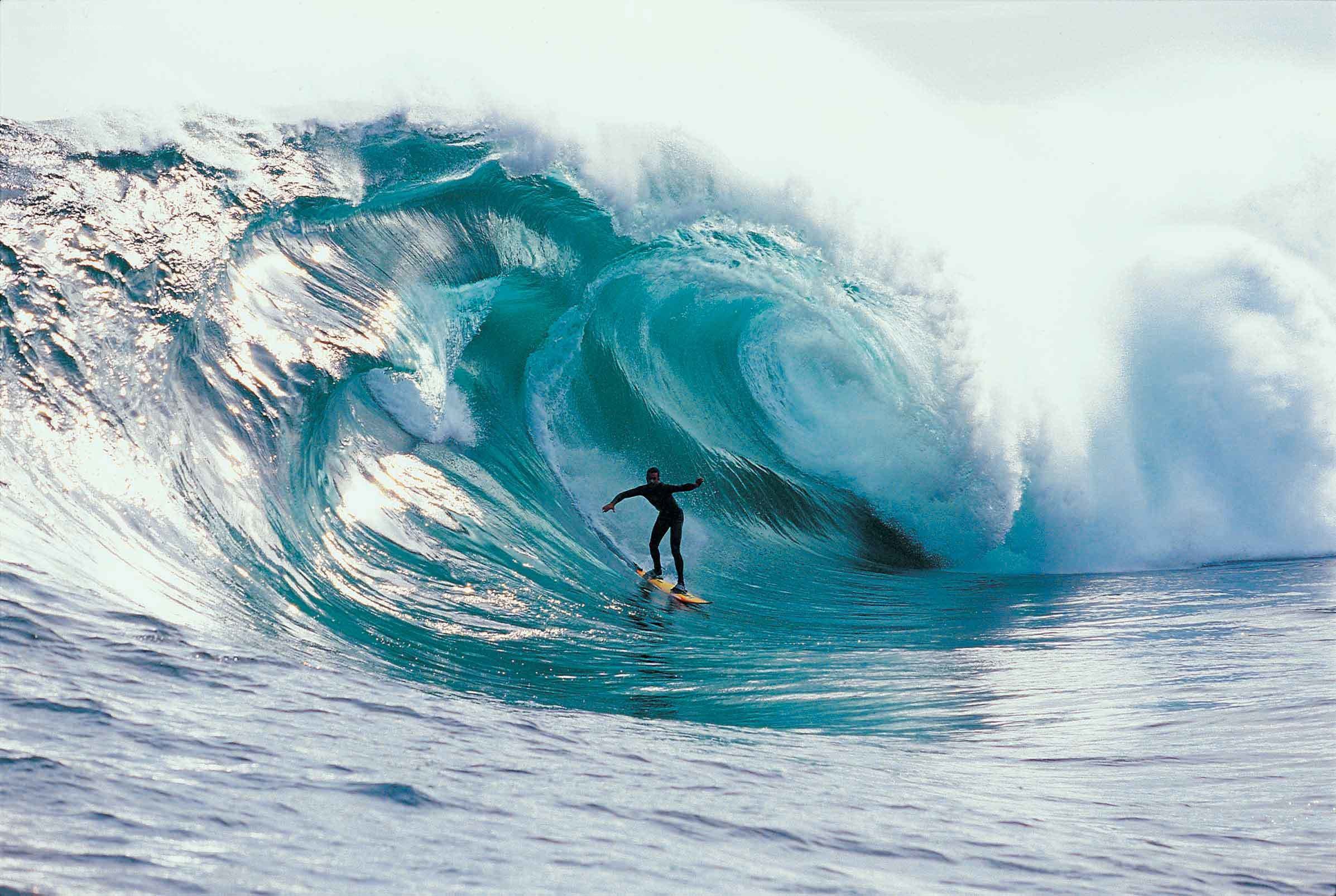 Surfer riding large ocean wave