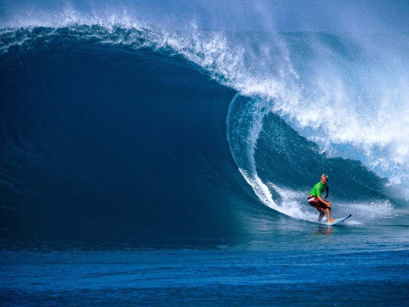 Surfer riding large ocean wave