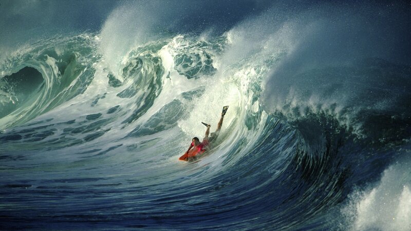 Surfer riding large ocean wave