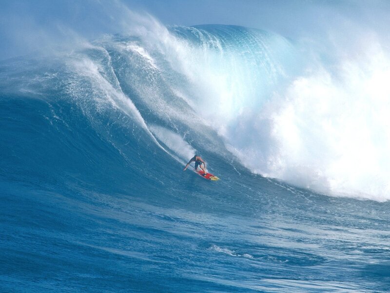Surfer riding large ocean wave