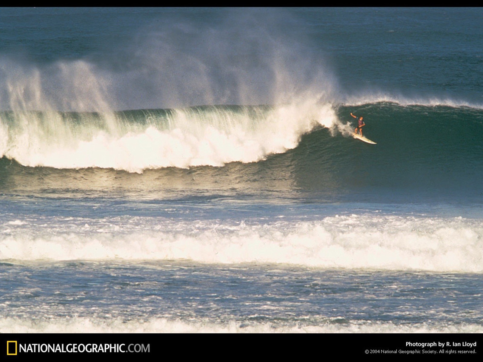 Surfer riding large wave