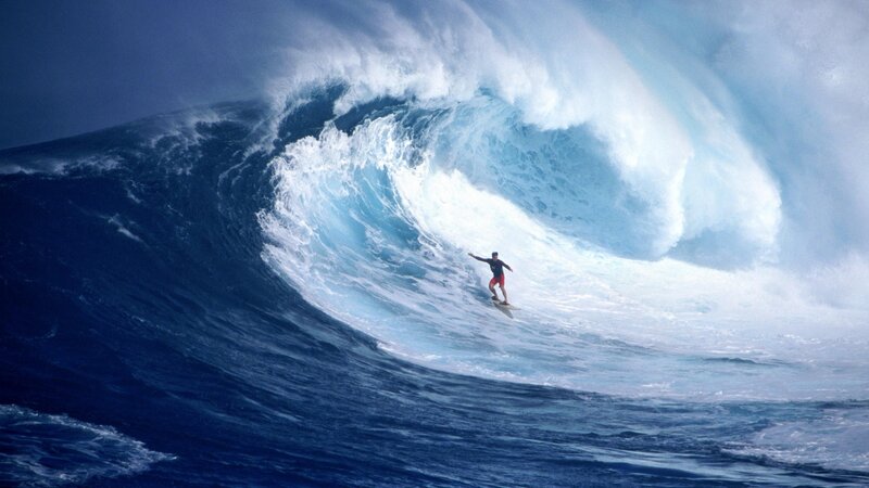 Surfer riding massive wave