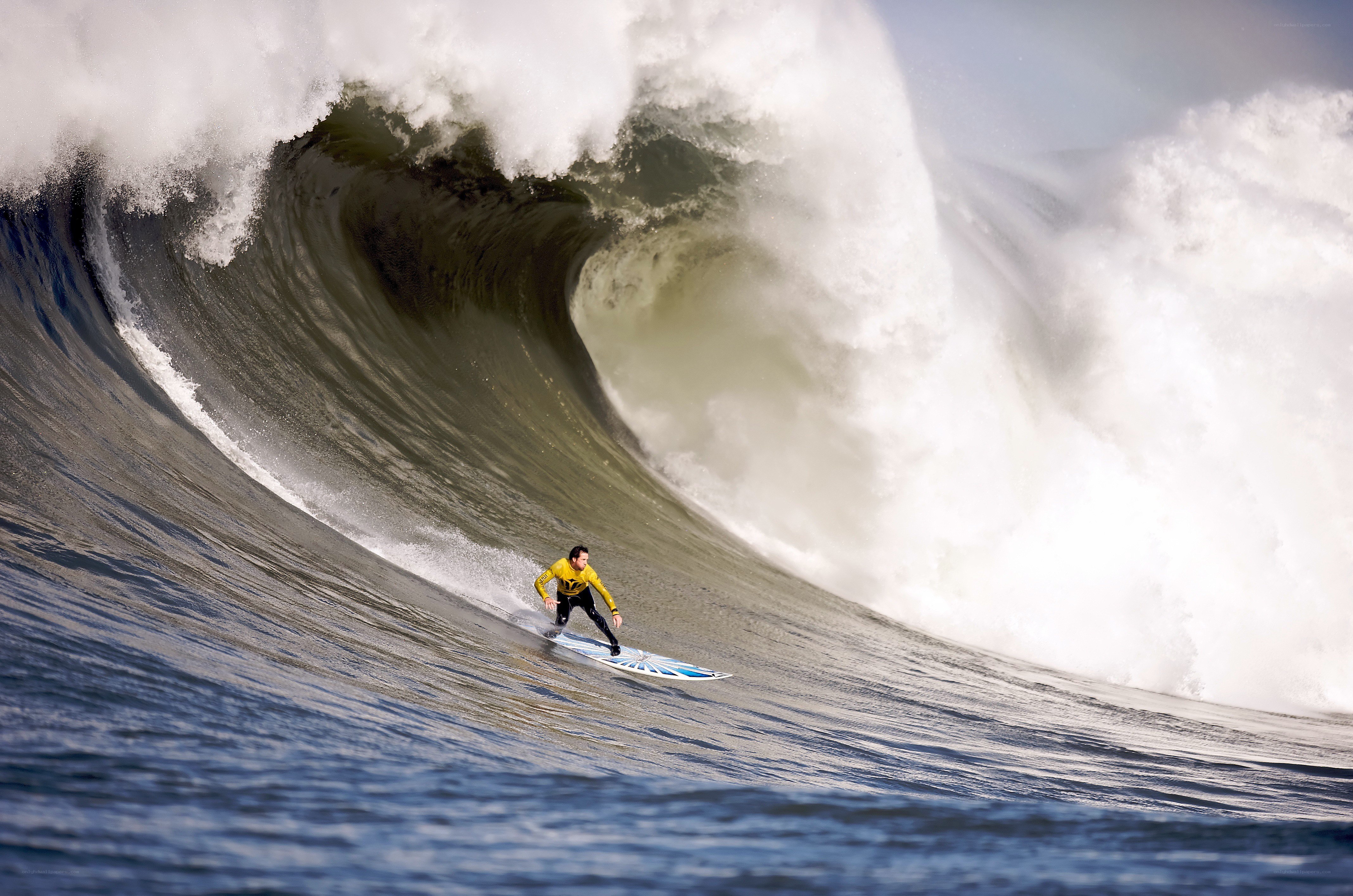 Surfer riding massive wave