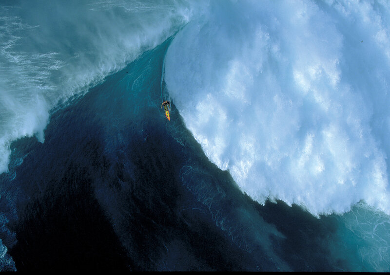 Surfer riding massive wave