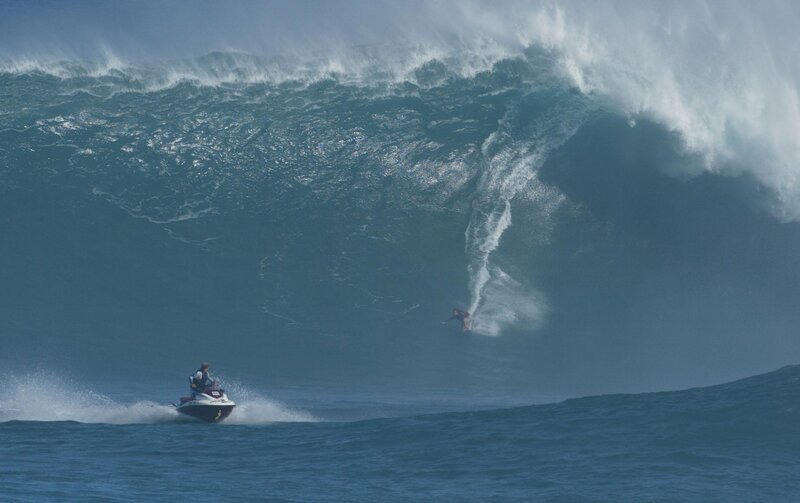 Surfer riding massive wave